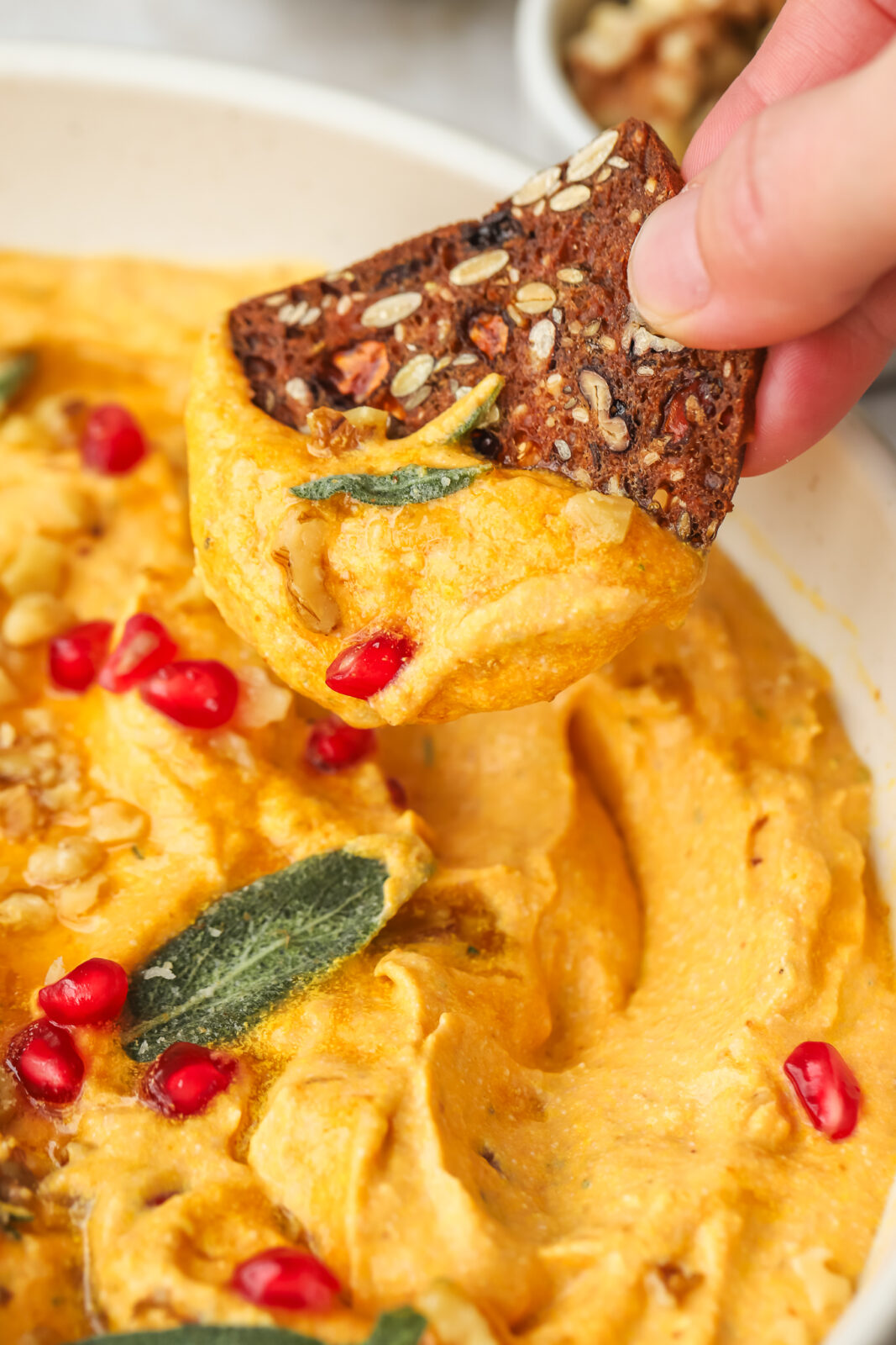 cracker dipping into pumpkin dip