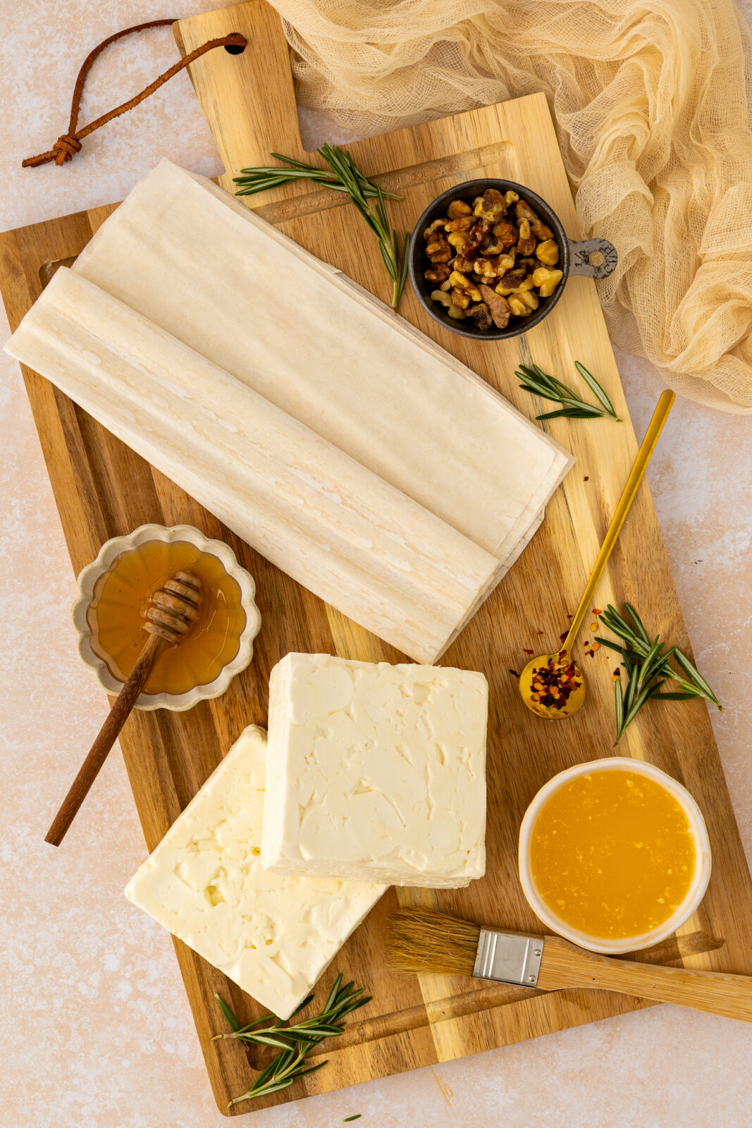 honey in a bowl, walnuts in a bowl, sheets of phyllo, pieces of feta cheese