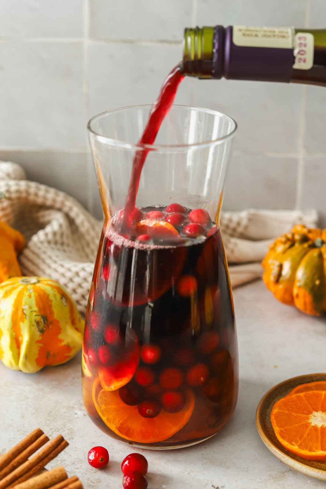 red wine being poured into a pitcher