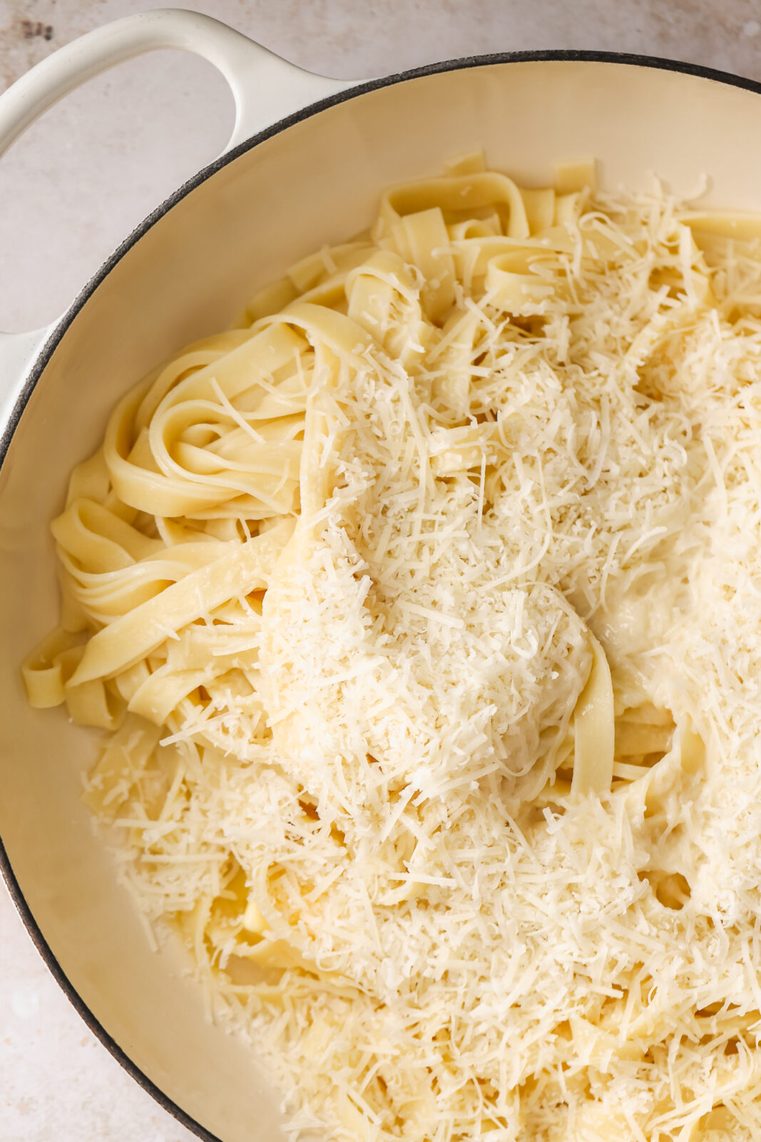 close up of freshly grated parmesan cheese on fettuccine noodles