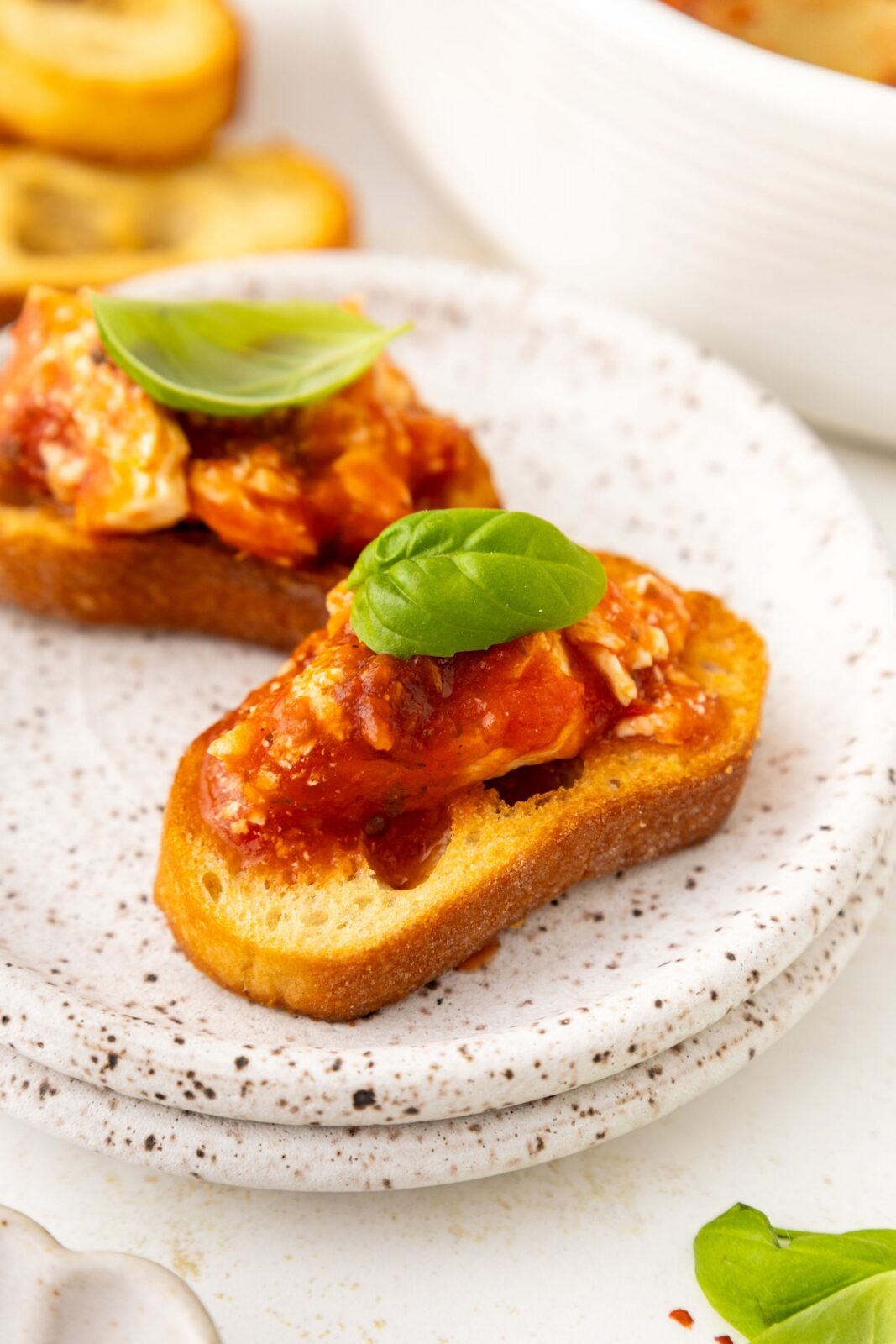 crostini with a piece of feta cheese and marinara sauce
