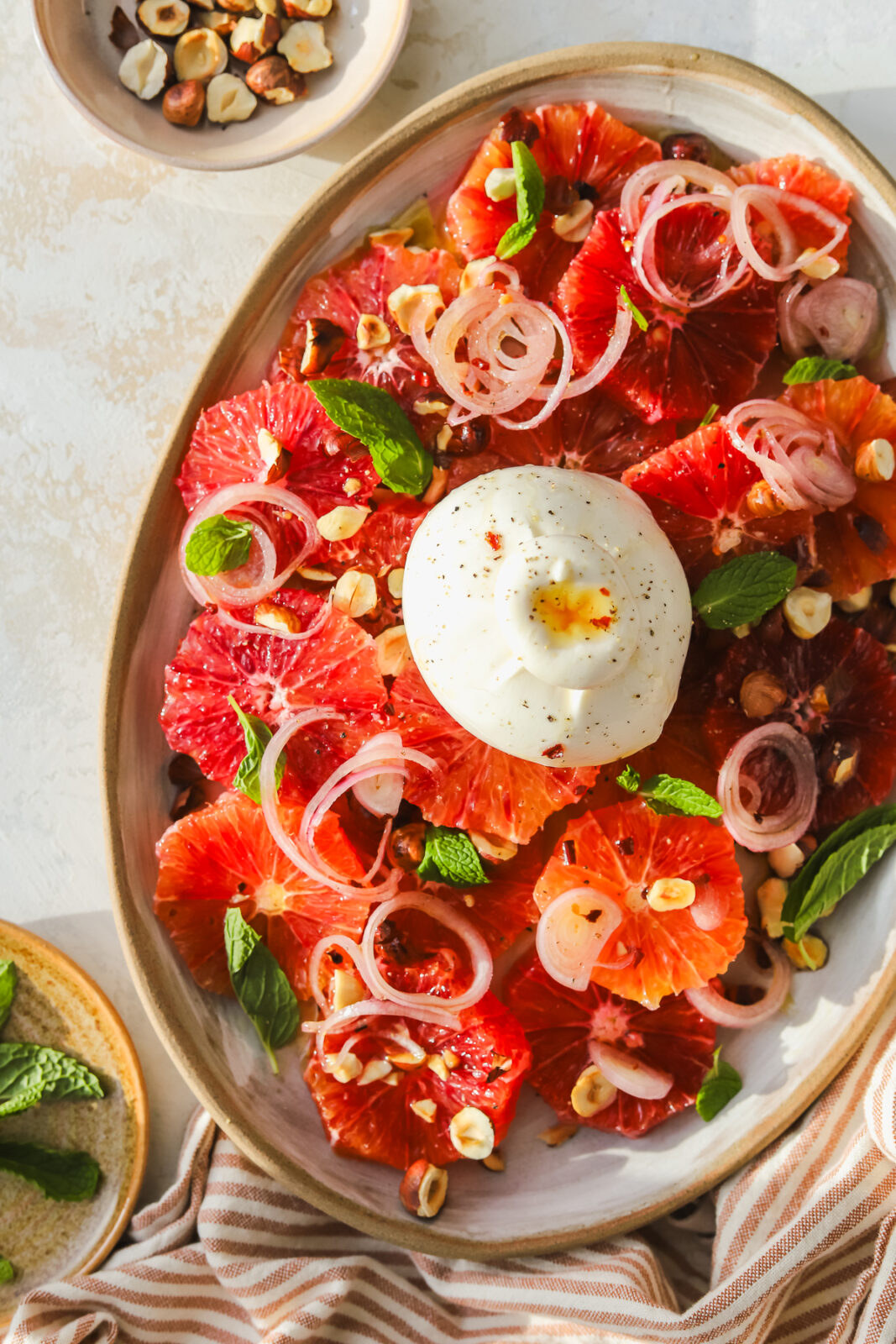 overhead of burrata ball on top of blood orange salad