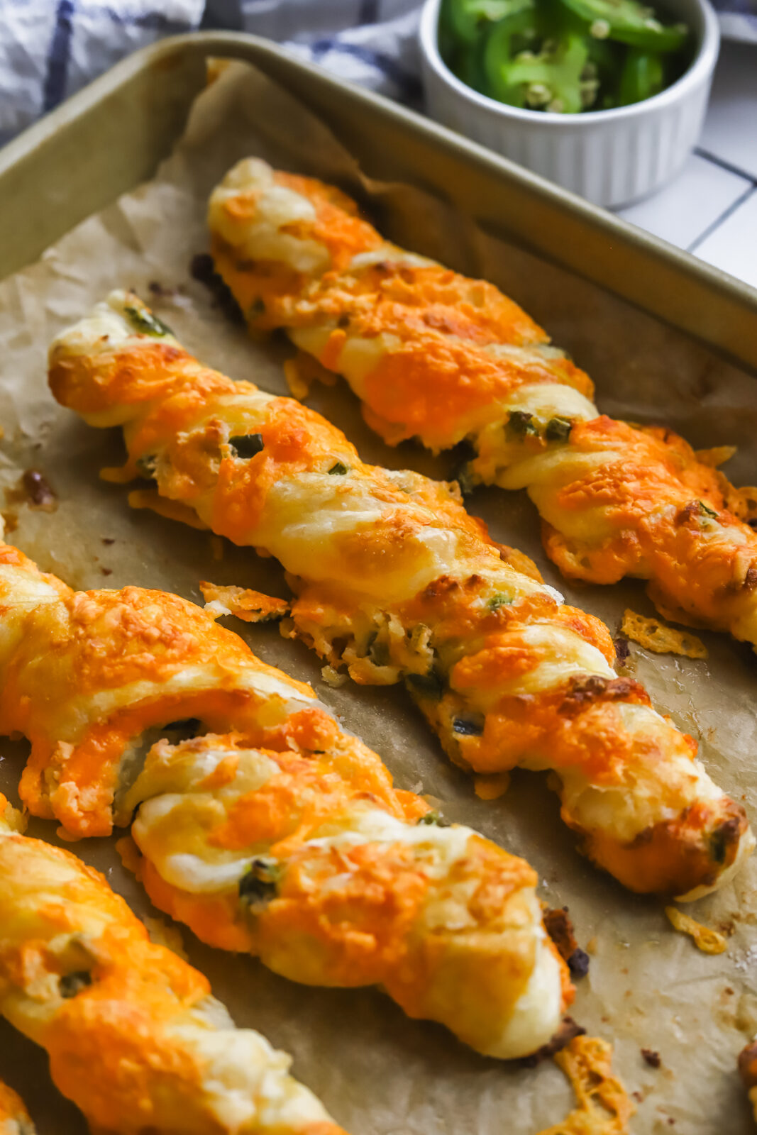 angled baked jalapeno popper cheese twists on a baking sheet