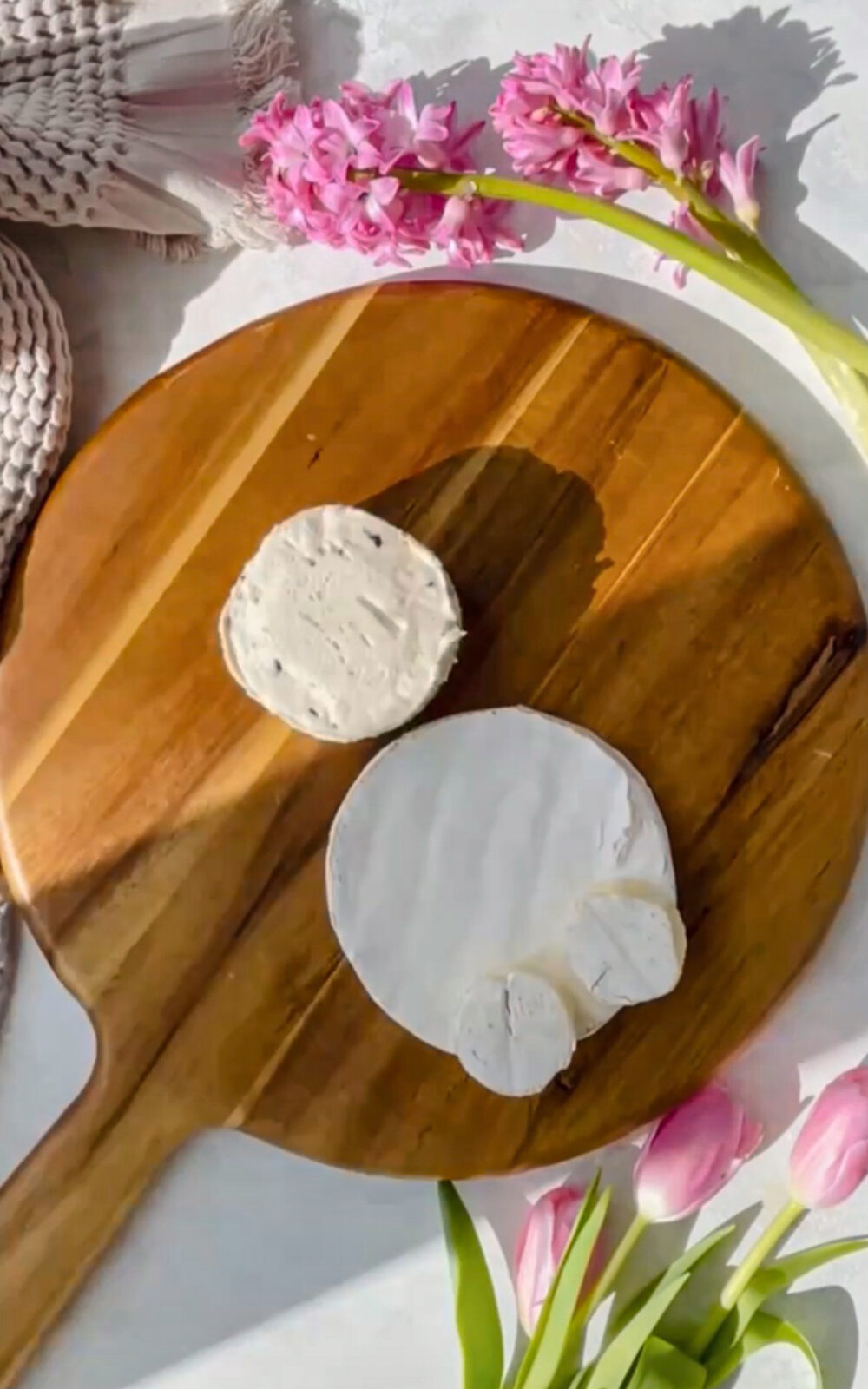 Boursin cheese and brie cheese on a wooden board