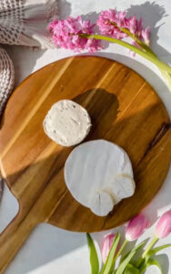 Boursin cheese and brie cheese on a wooden board
