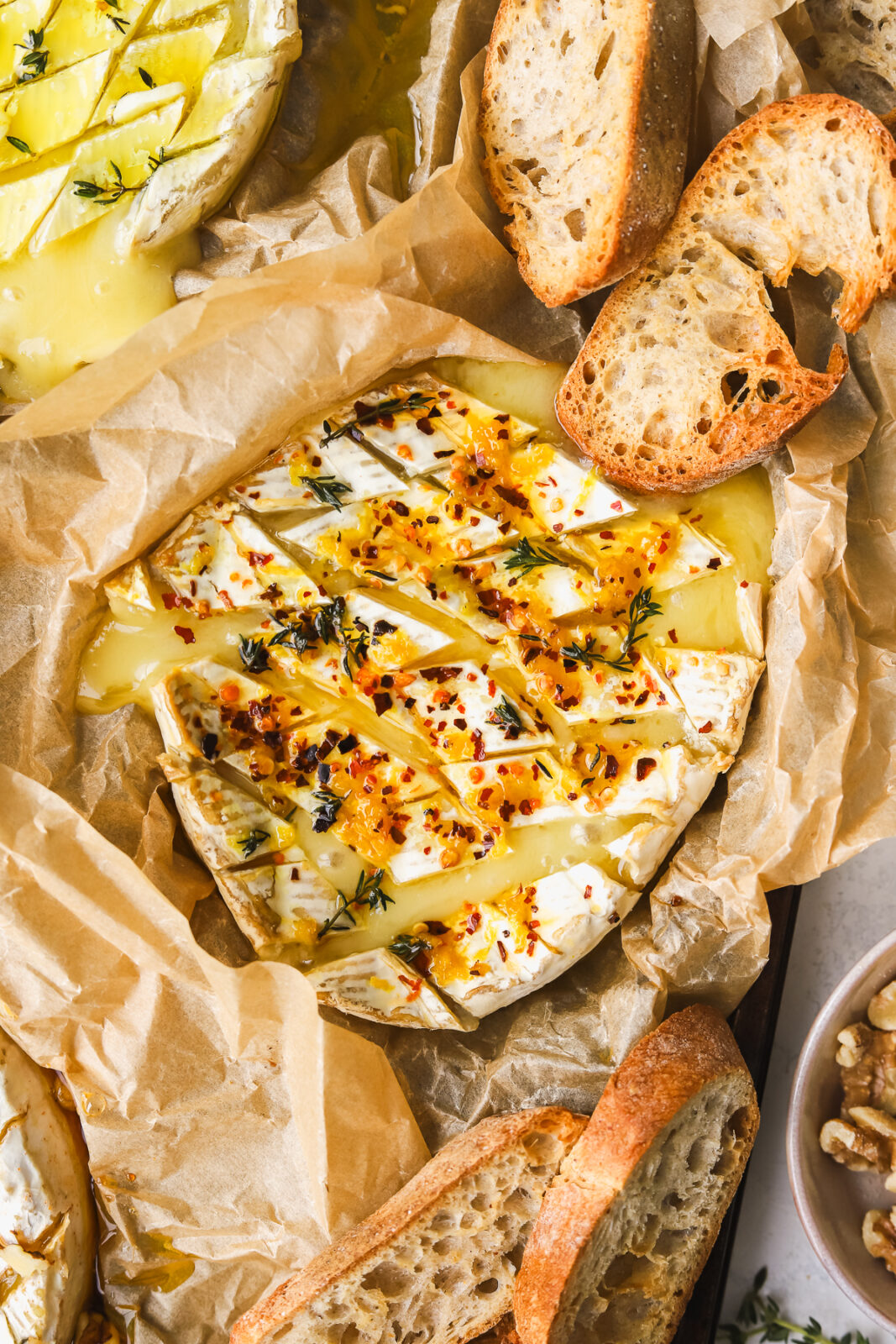 baked camembert cheese with lemon zest, herbs and chili flakes