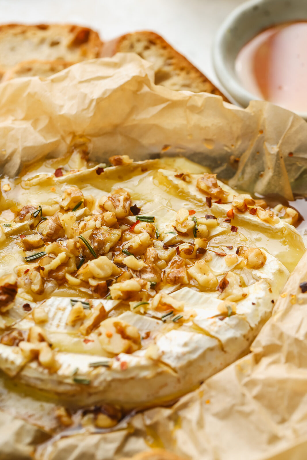 a wheel of melty camembert cheese seasoned with walnuts and hot honey