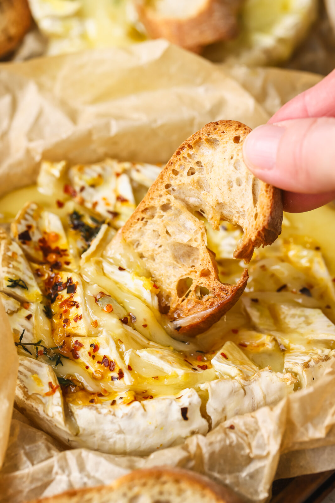 crostini dipping into melty cheese