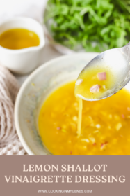 lemon shallot vinaigrette on a spoon being drizzled in to a bowl