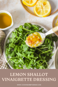 lemon shallot vinaigrette on a spoon being drizzled on a salad