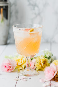cocktail glass with grapefruit juice, lavender bitters and gin and florals