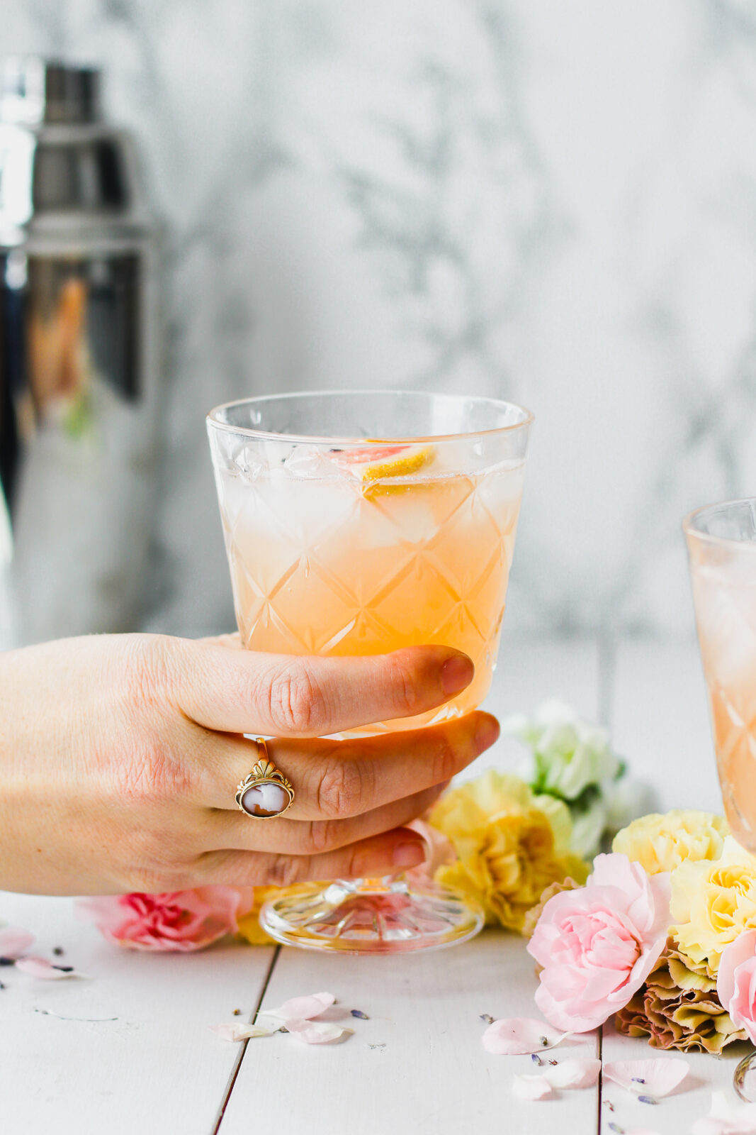 hand holding grapefruit lavender cocktail