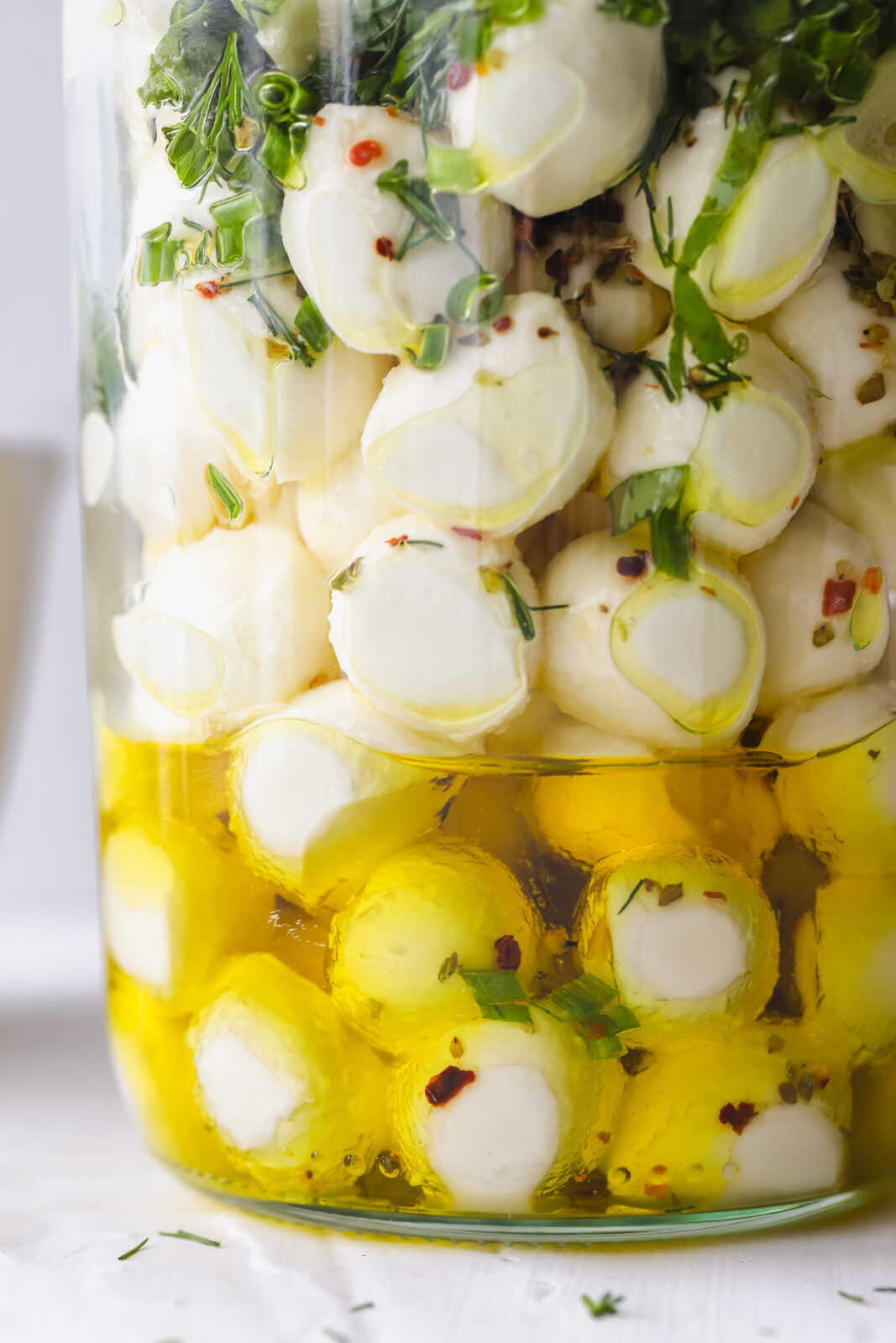 close up of mozzarella balls marinated in olive oil and herbs