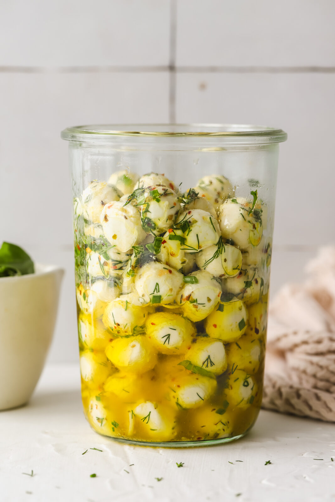 large glass jar with marinated mozzarella balls