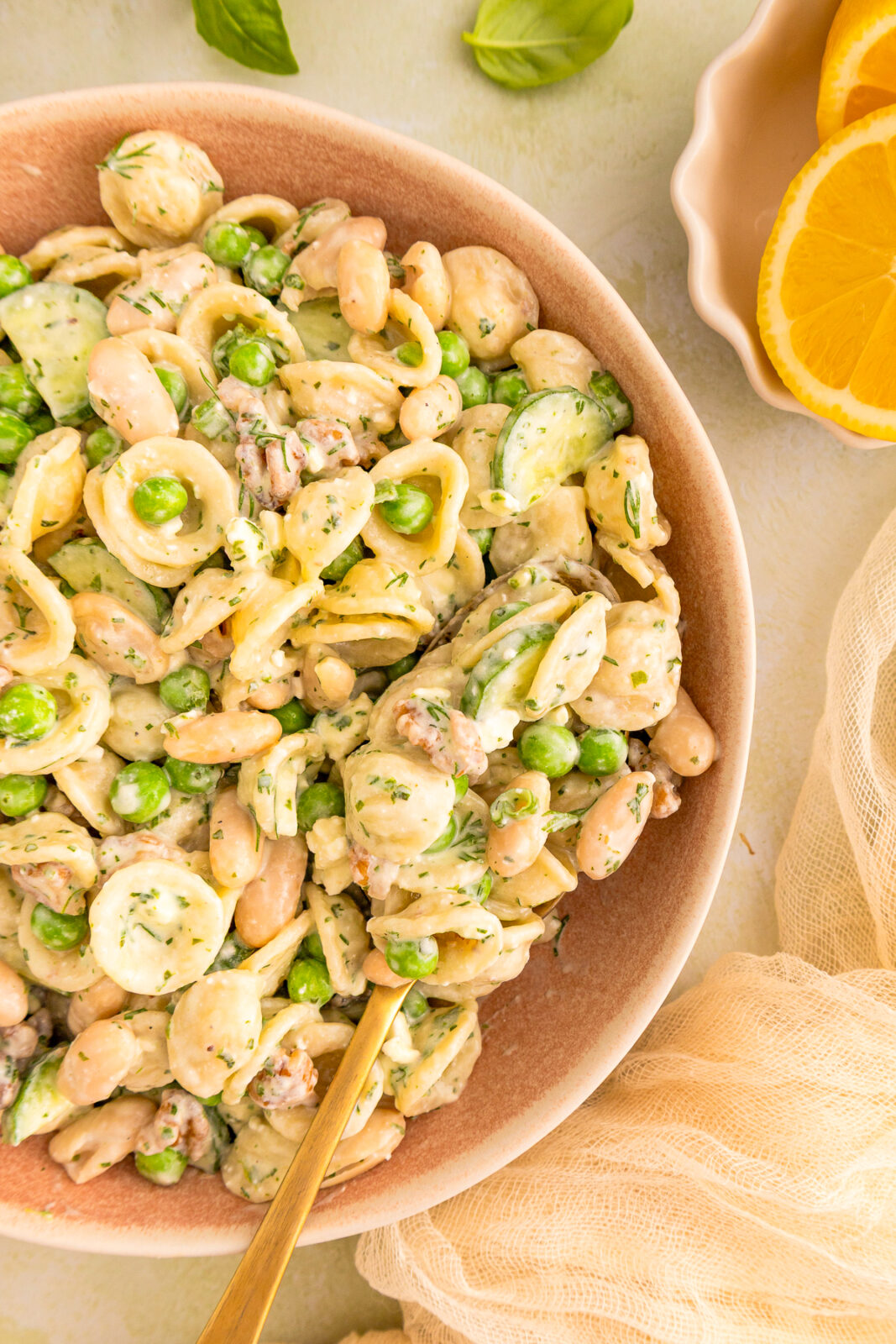 close up of a spoon in a serving bowl of pasta salad
