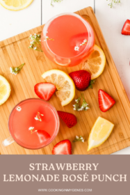 strawberry lemonade cocktail on a serving board with slices of lemons and strawberries