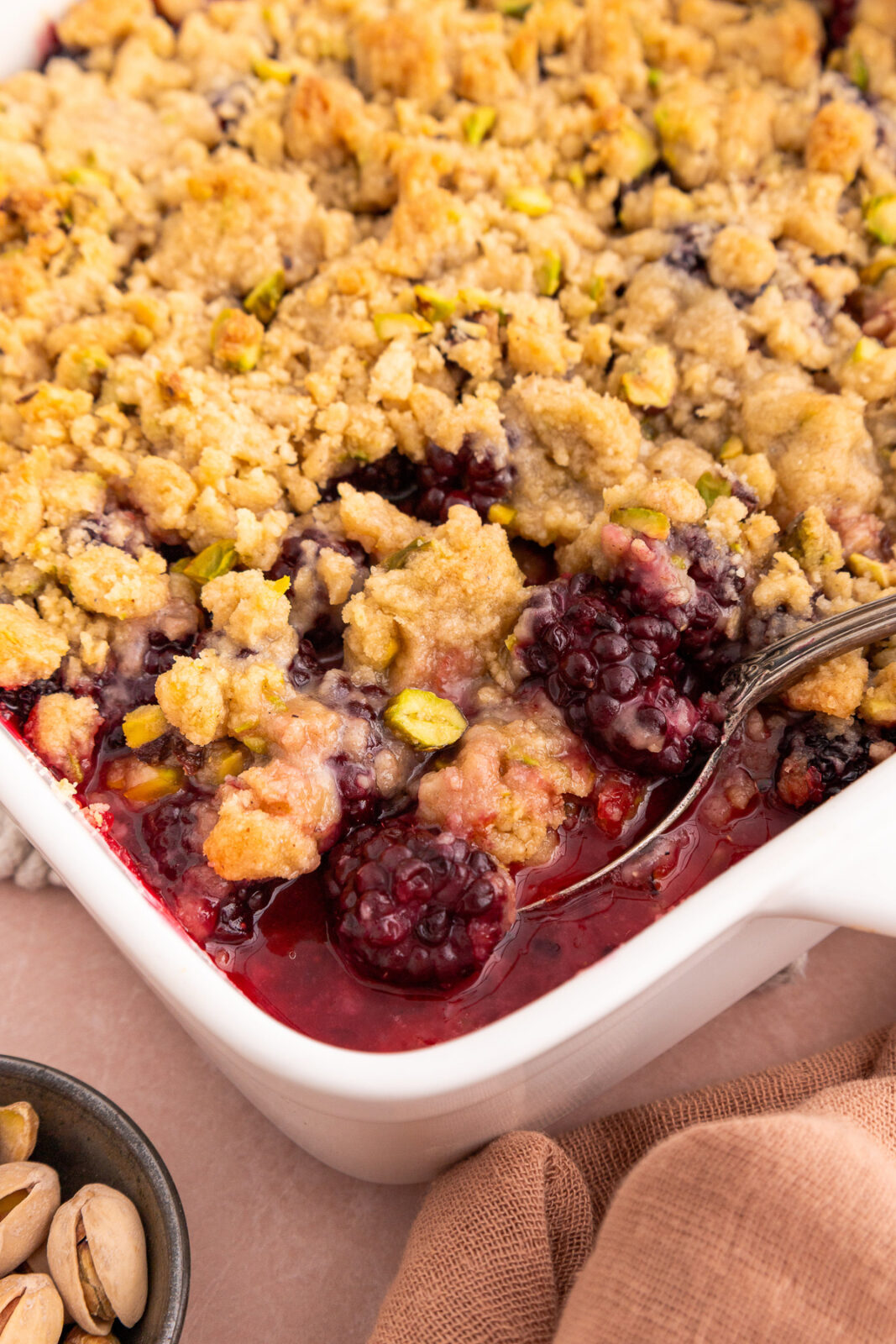 close up of a spoon in a fruit crumble