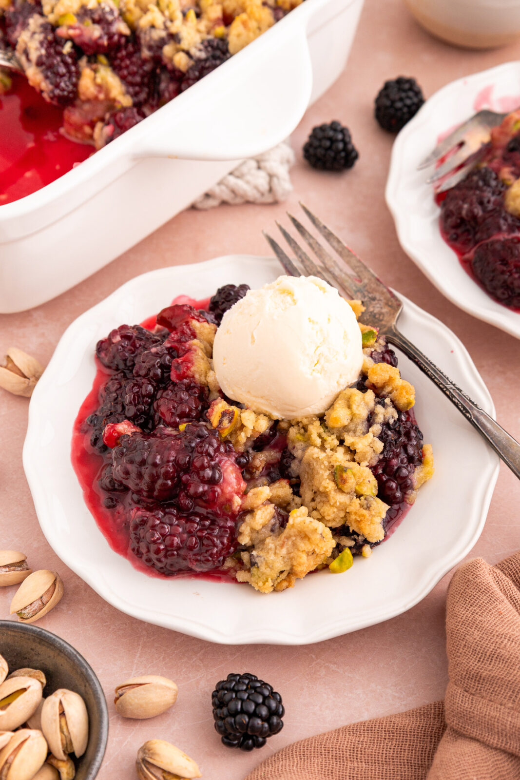 blackberry crumble on a plate with a scoop of ice cream