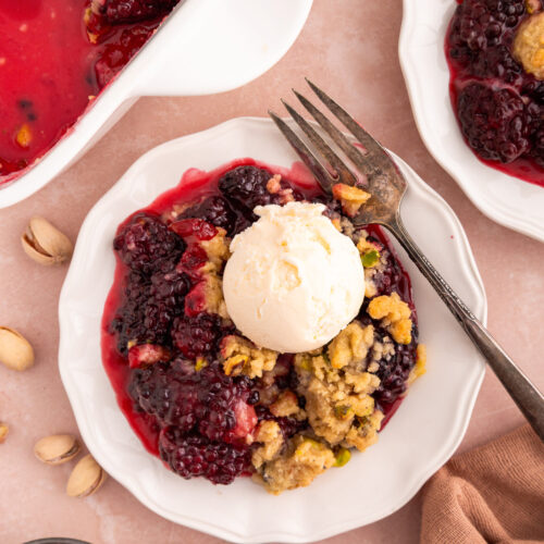 blackberry crumble on a plate with a scoop of ice cream