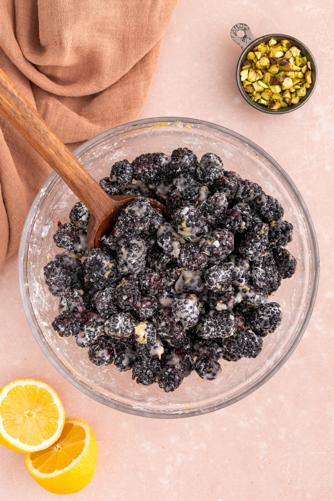 blackberries in a bowl with a wooden spoon