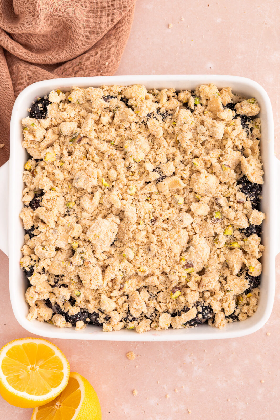 crumble topping over blackberries in a baking dish