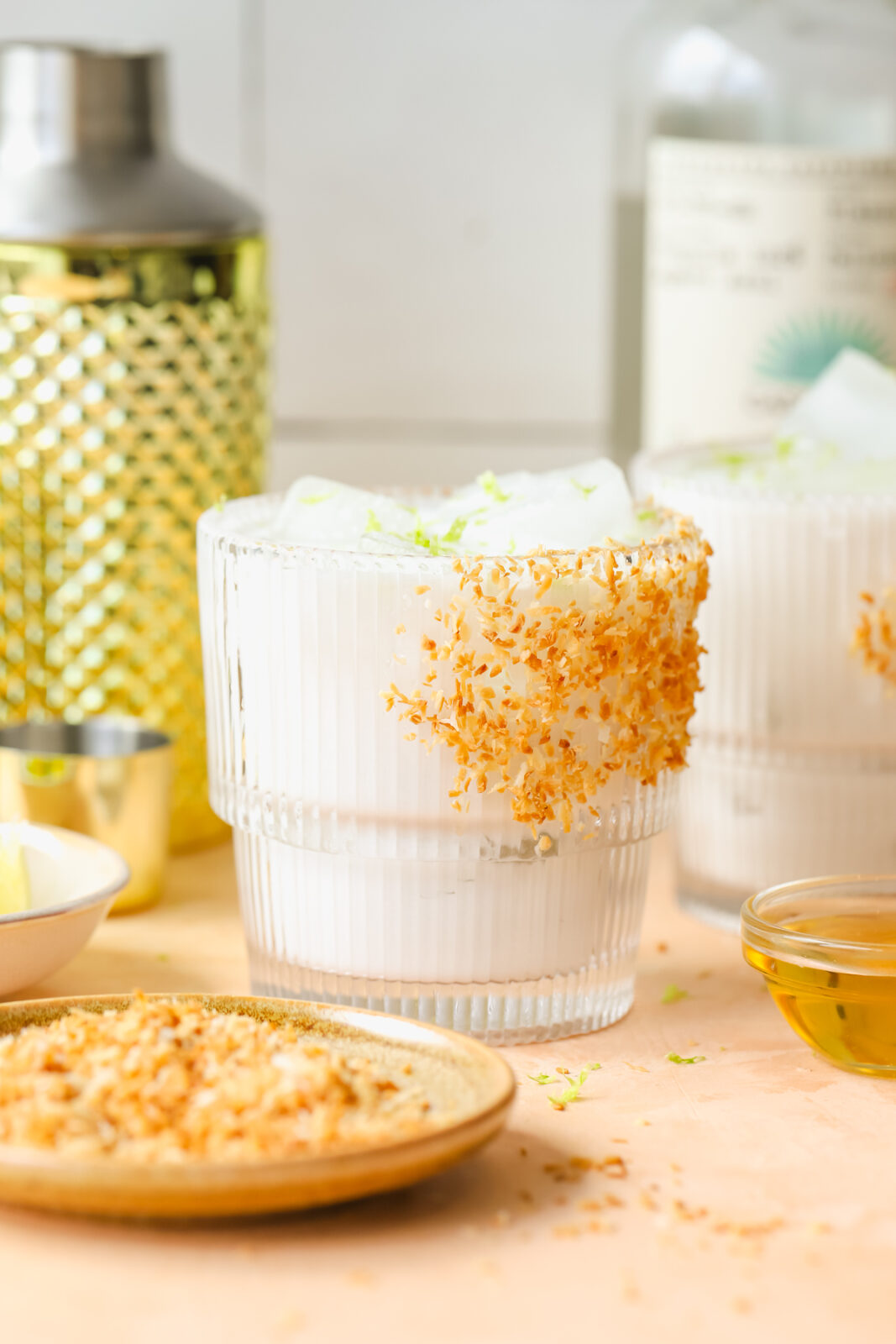 close up of coconut margarita in a glass garnished with toasted coconut