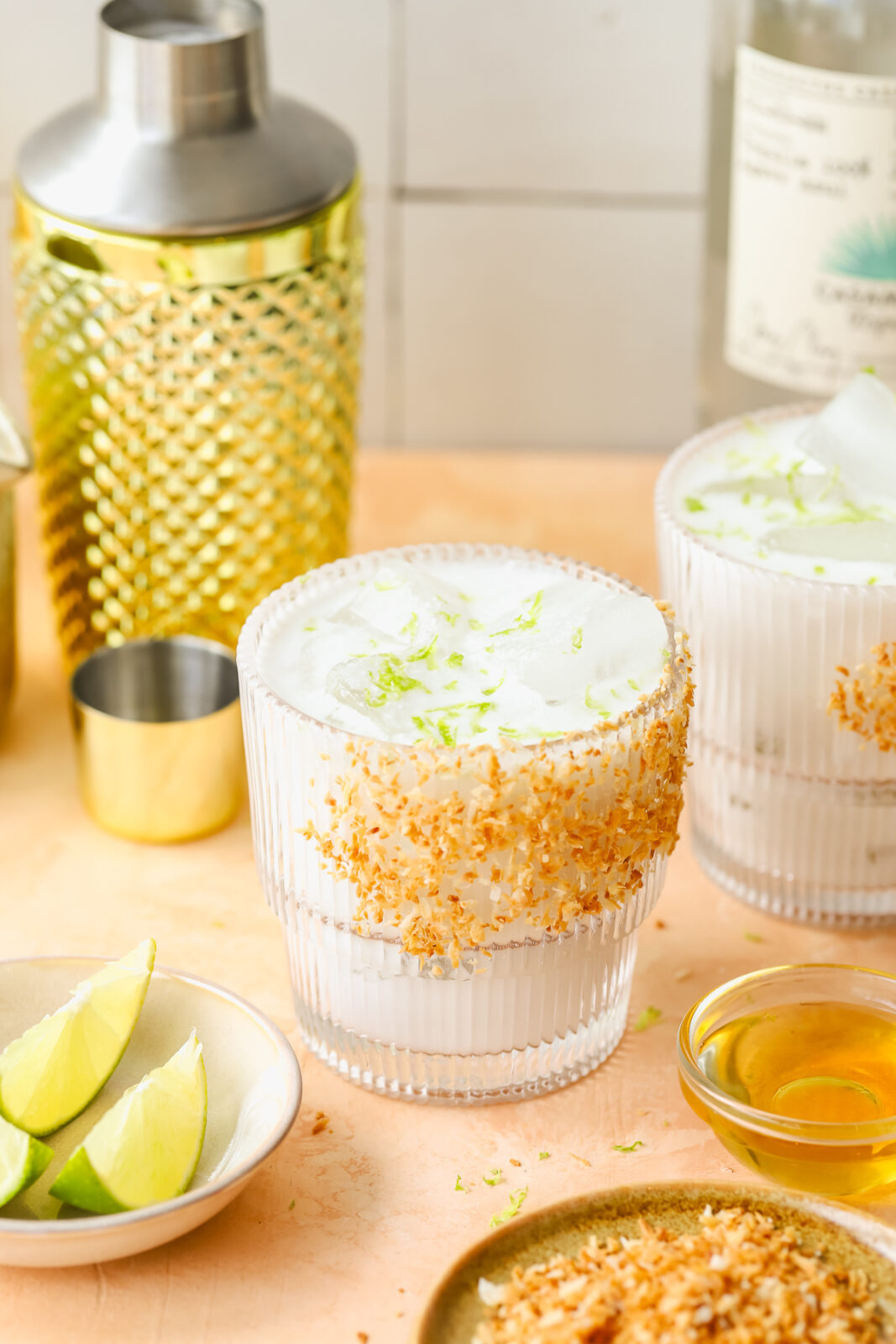 angled photo of a coconut margarita in a toasted coconut rimmed glass