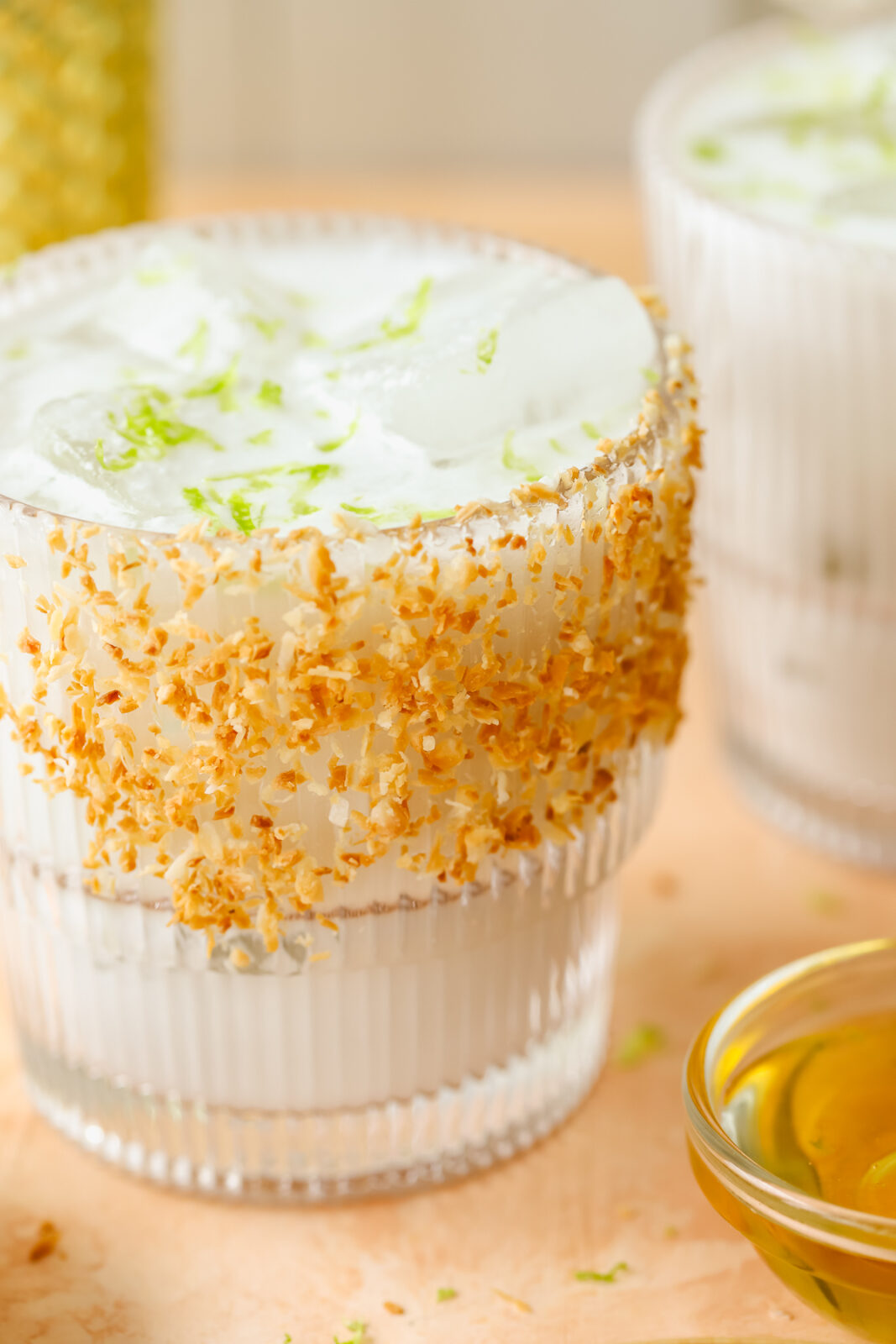close up of a glass with a toasted coconut garnish