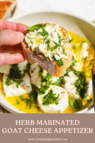 hand holding a piece of bread with goat cheese spread on top
