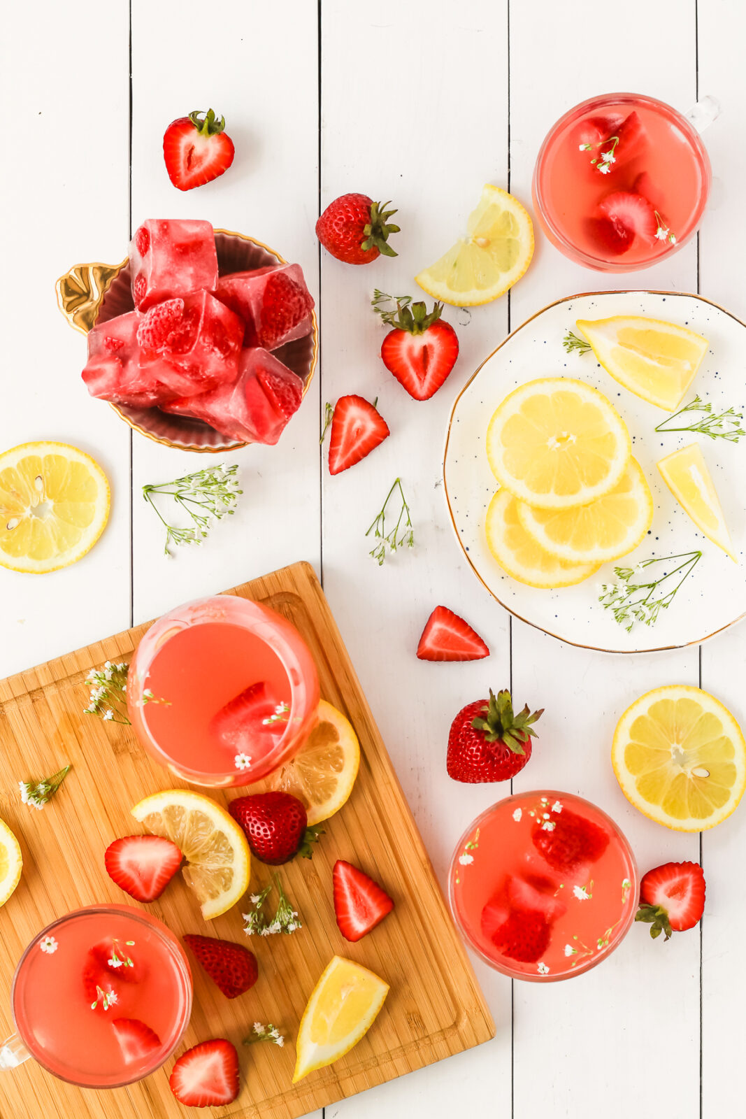 lemon slices, strawberries, cocktail glasses being prepared