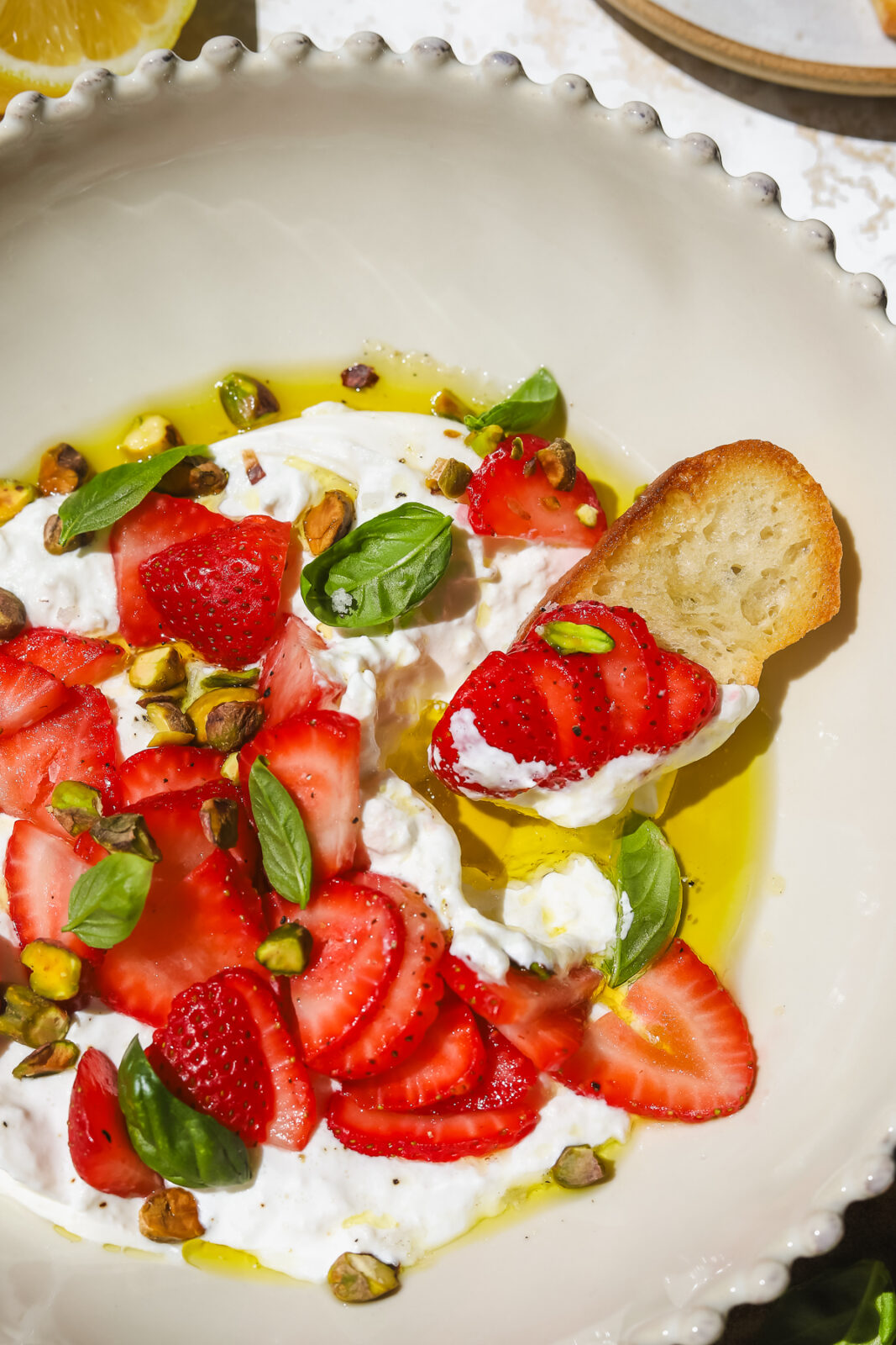 crostini dipped into strawberry burrata appetizer in a bowl