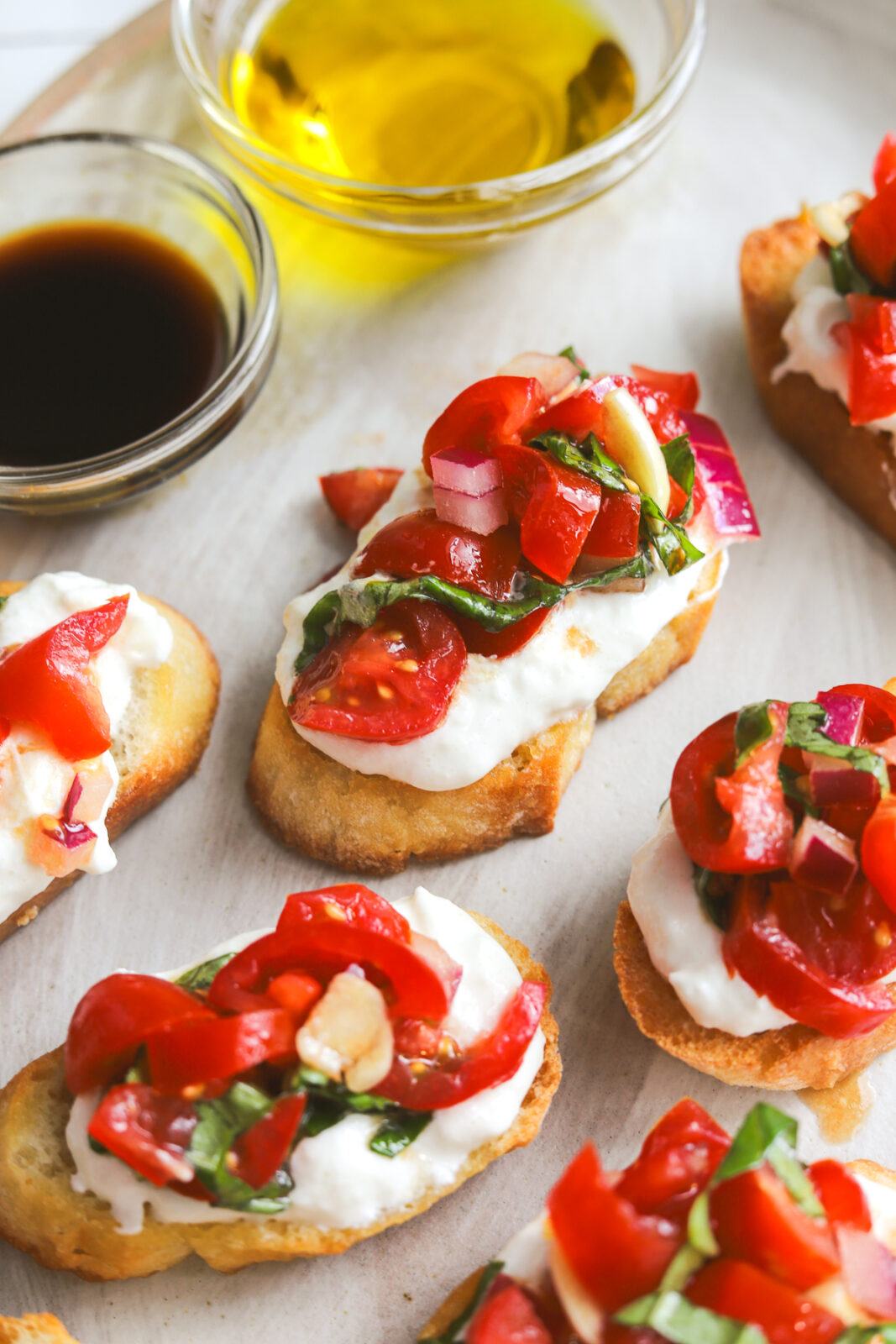 angled photo of bruschetta on crostini with burrata