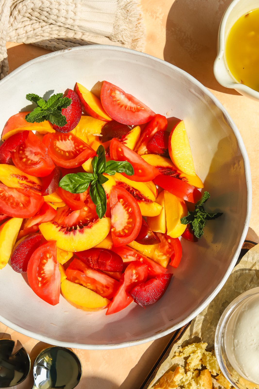 slices of peaches, nectarines, tomatoes and plums in a bowl