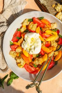 overhead photo of panzanella salad in a large bowl with burrata