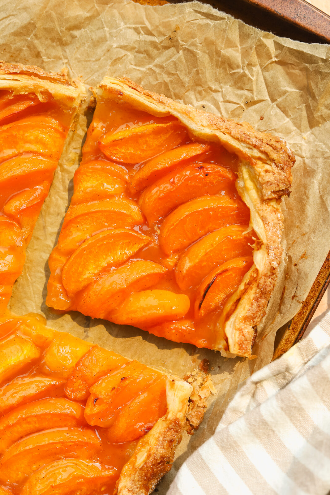 a piece of puff pastry apricot tart on a baking sheet