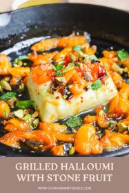 angled photo of grilled halloumi with apricot slices in a cast-iron pan