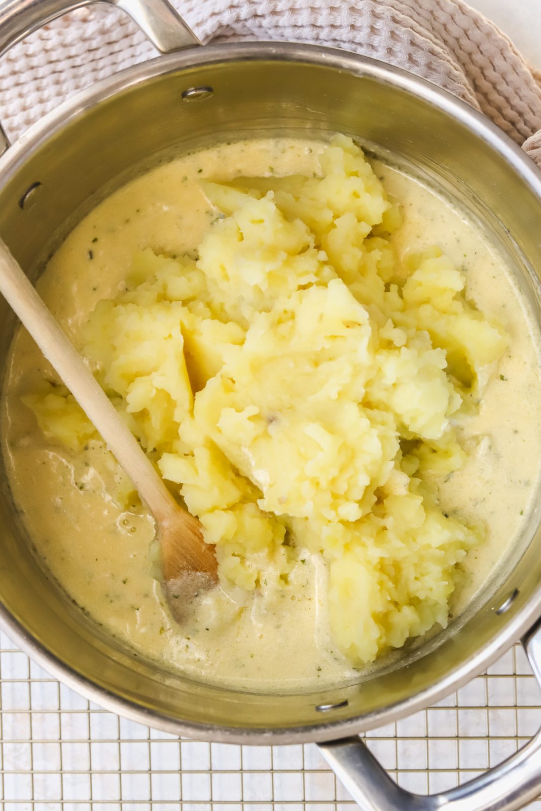 mashed potatoes in a pot with a wooden spoon