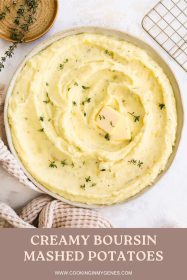 Boursin mashed potatoes in a bowl garnished with thyme leaves and a pat of butter