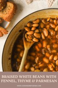 close-up of braised white bean on a wooden spoon in a braiser
