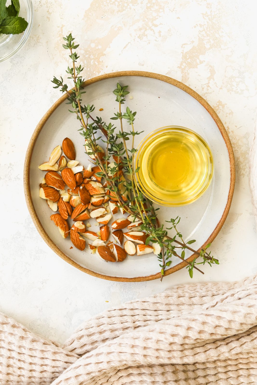chopped almonds, fresh thyme sprigs and honey on a plate