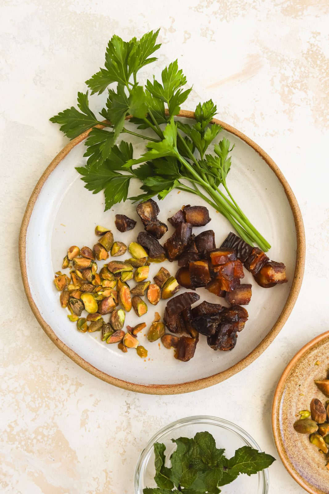 chopped dates, chopped pistachios and fresh parsley on a plate