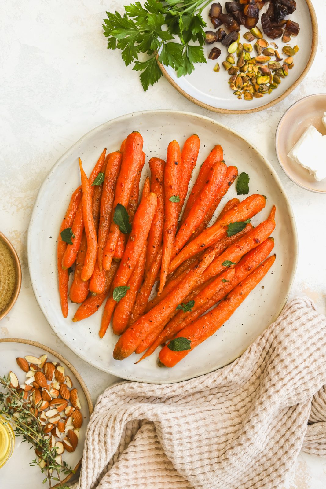 whole roasted carrots on a serving dish garnished with mint