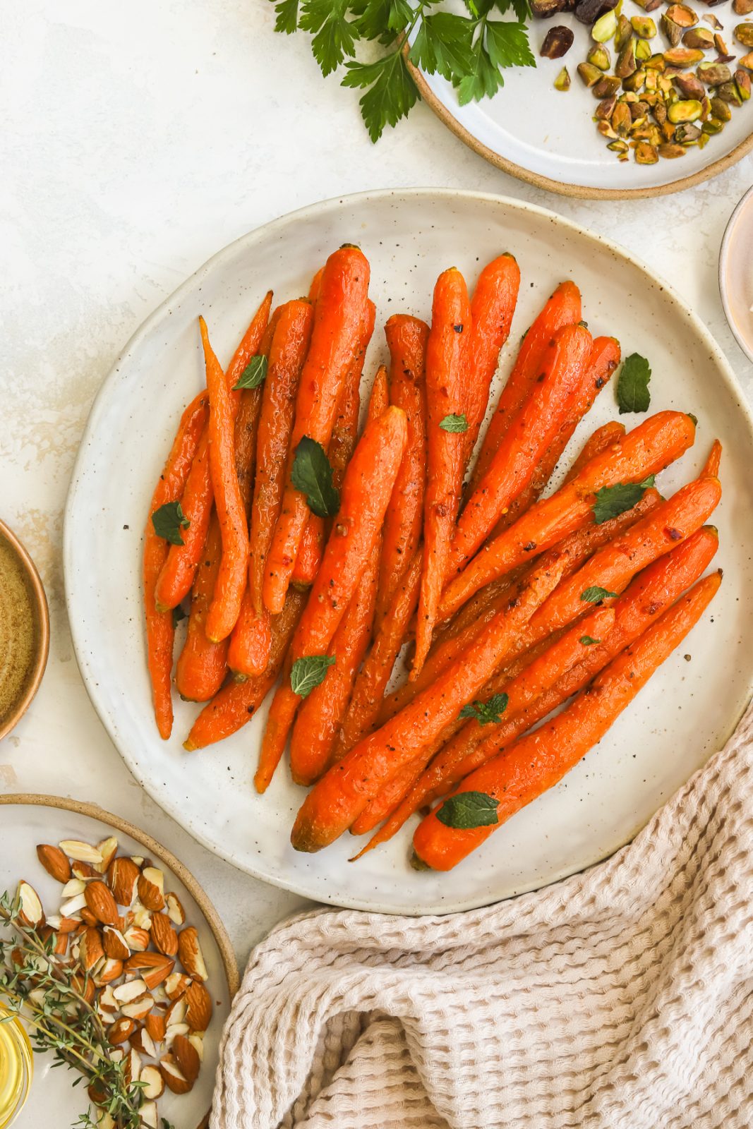 whole roasted carrots on a serving dish garnished with mint