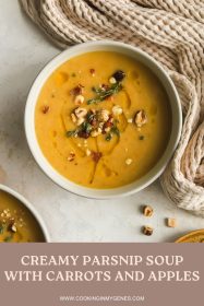 creamy parsnip soup in a bowl garnished with olive oil drizzle, chopped hazelnuts and fresh thyme