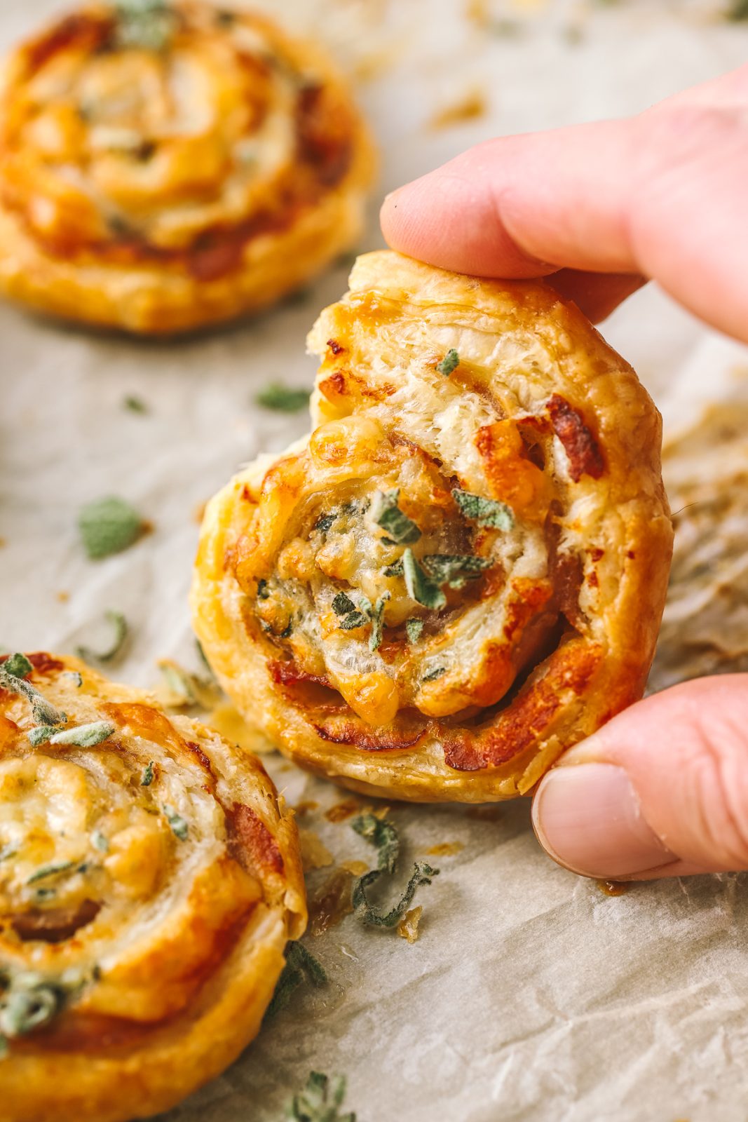 hand holding a puff pastry pinwheel as a Thanksgiving appetizer