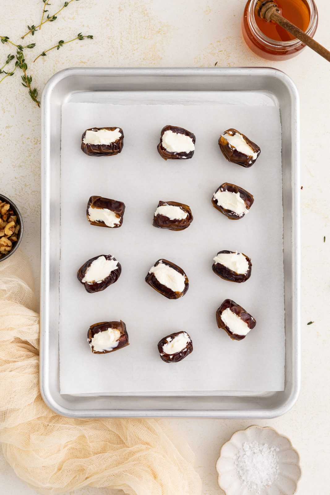 dates on a baking sheet stuffed with cream cheese