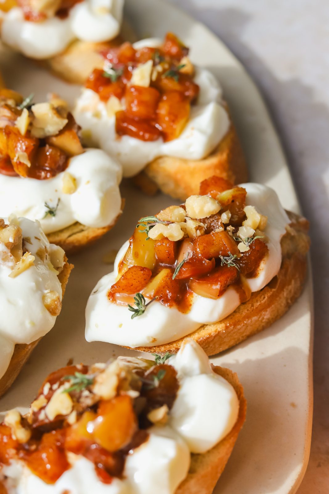 crostini with maple apples and whipped ricotta on a serving platter