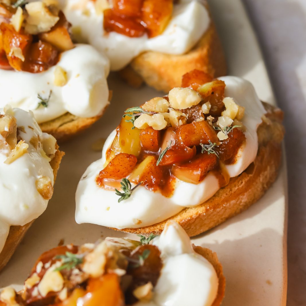 crostini with maple apples and whipped ricotta on a serving platter